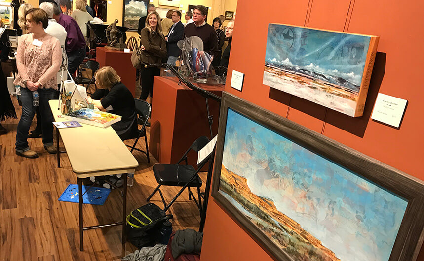 Artwork hanging in a busy art exhibit